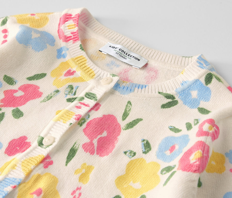 Vue détaillée d'une jaquette en maille pour enfant avec un motif floral.