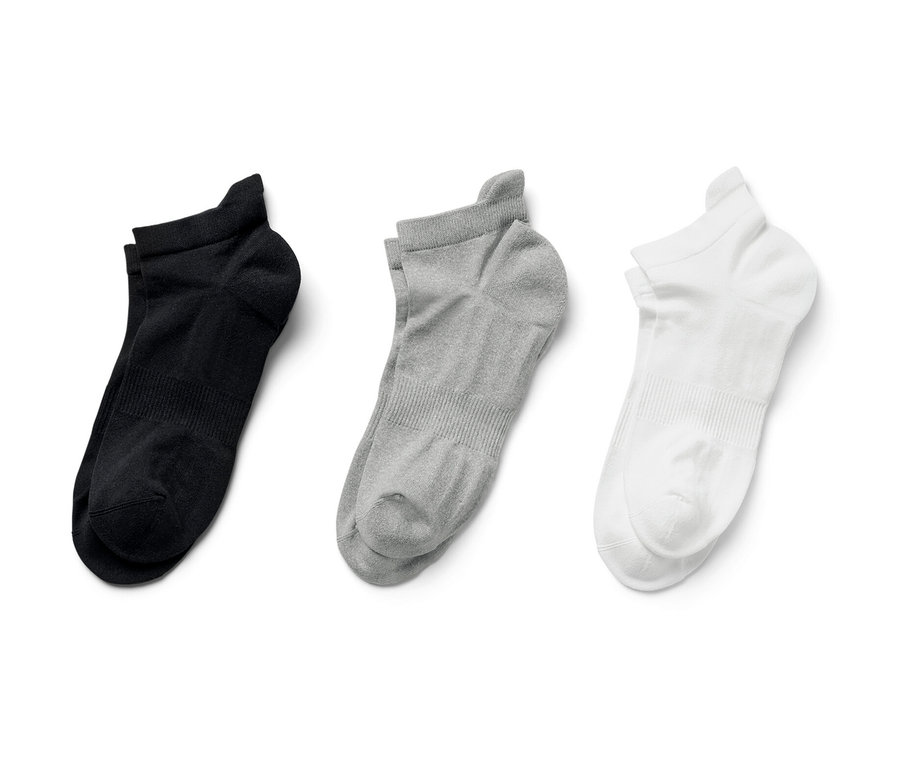 Trois paires de chaussettes de sport fonctionnelles, en noir, gris et blanc.