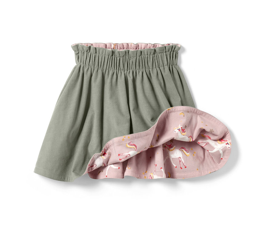 Une jupe réversible en velours pour enfant, un côté est gris et l'autre rose avec un imprimé licorne.