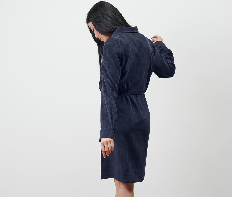 Femme regardant vers le bas et portant une robe en velours côtelé.