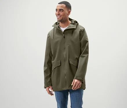 Un homme debout portant une veste d'extérieur.