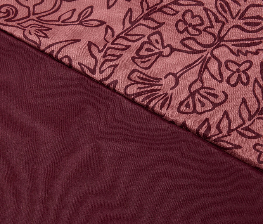 Gros plan d'un tissu bordeaux avec motif floral.