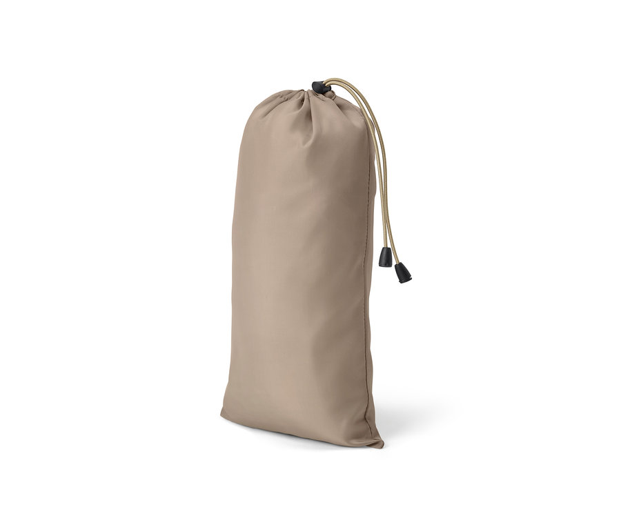 Une moustiquaire de voyage enroulée dans un sac en tissu beige avec un cordon de serrage.