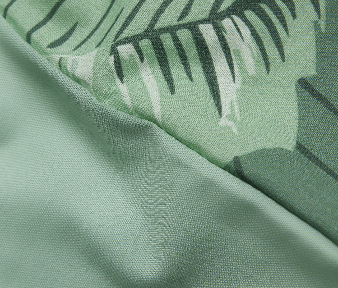 Détail d'une parure de lit en renforcé taille normale avec un motif de palmiers.