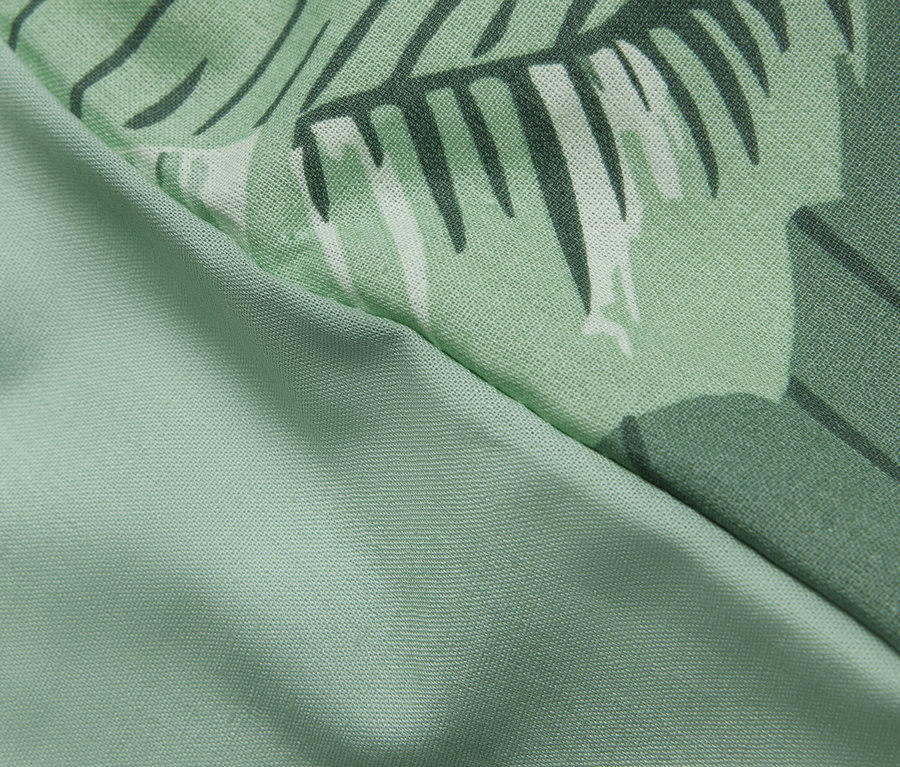 Détail d'une parure de lit en renforcé taille normale avec un motif de palmiers.