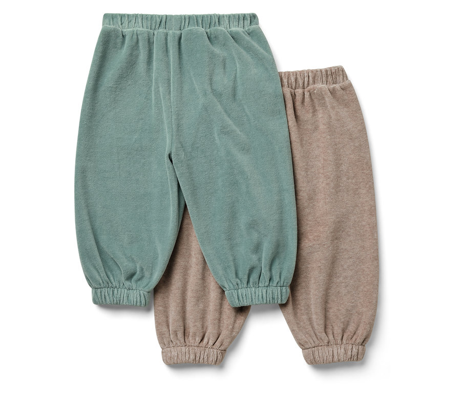 Deux pantalons pour enfants : un bleu-vert, l'autre beige.
