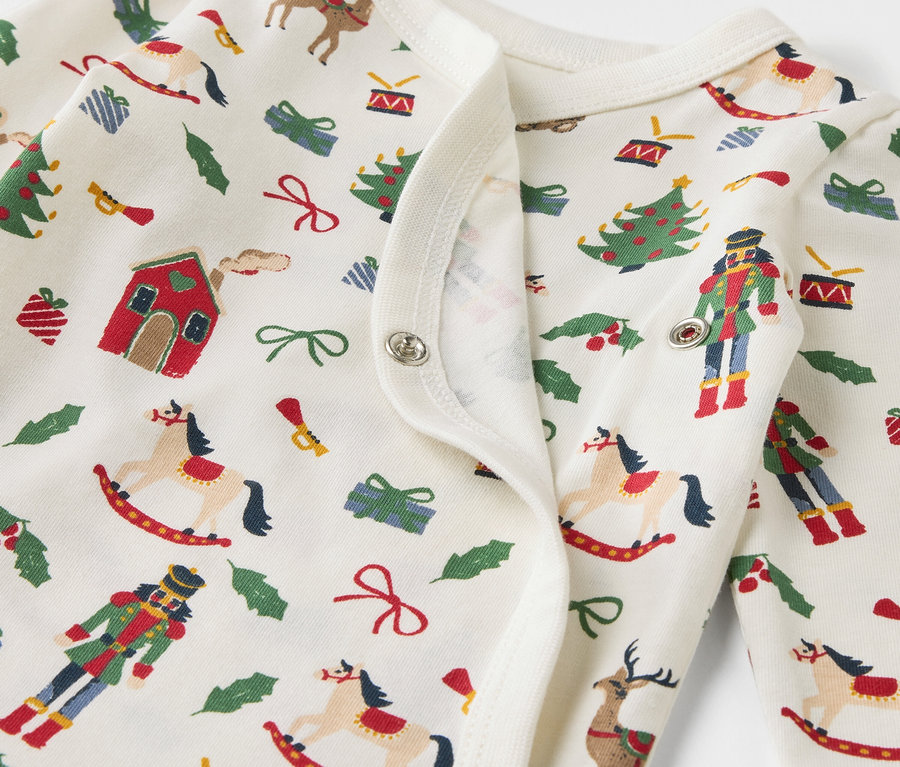 Détail d'un body en coton avec un imprimé de Noël.