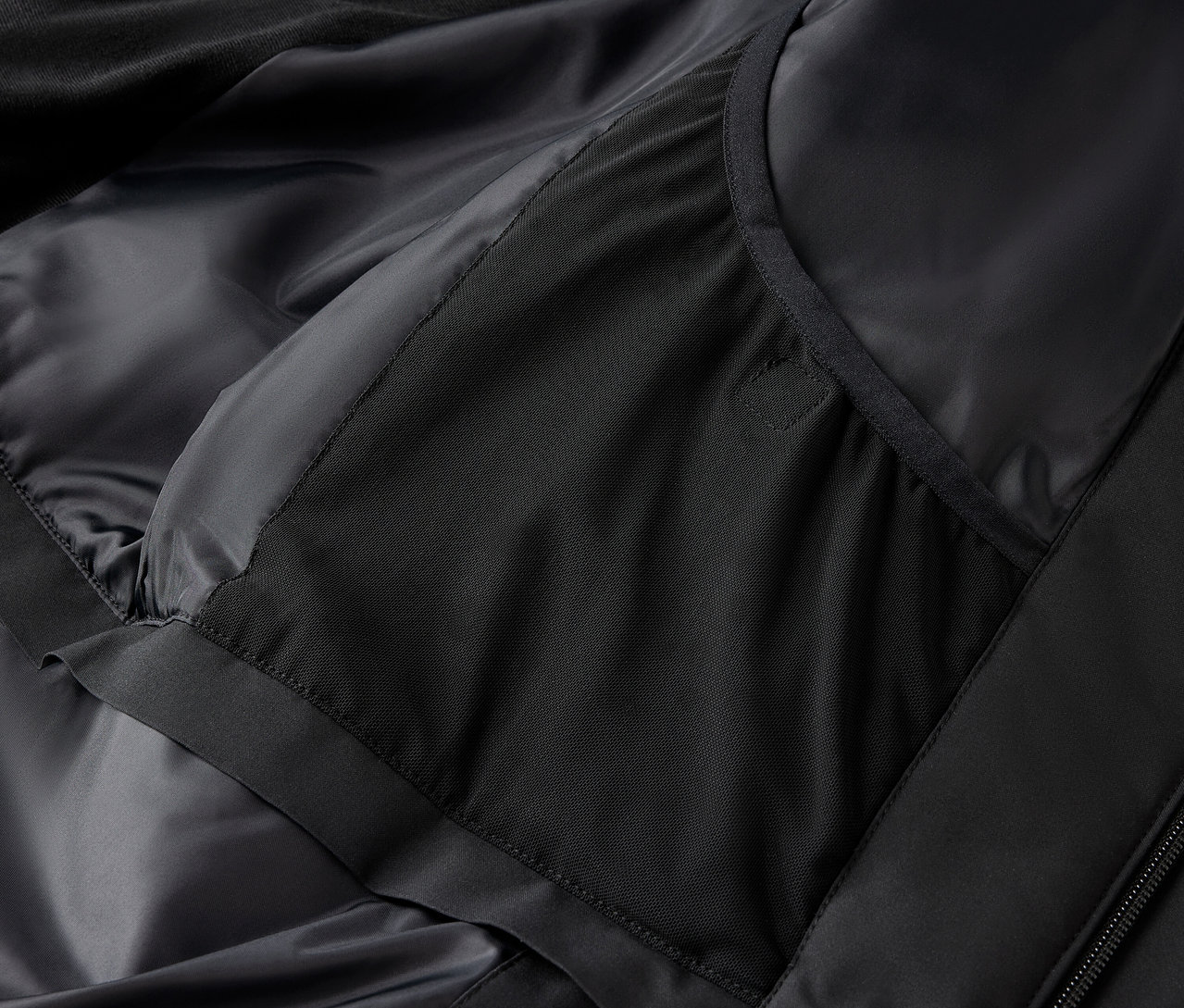 Détail d'une veste noire avec une poche intérieure.
