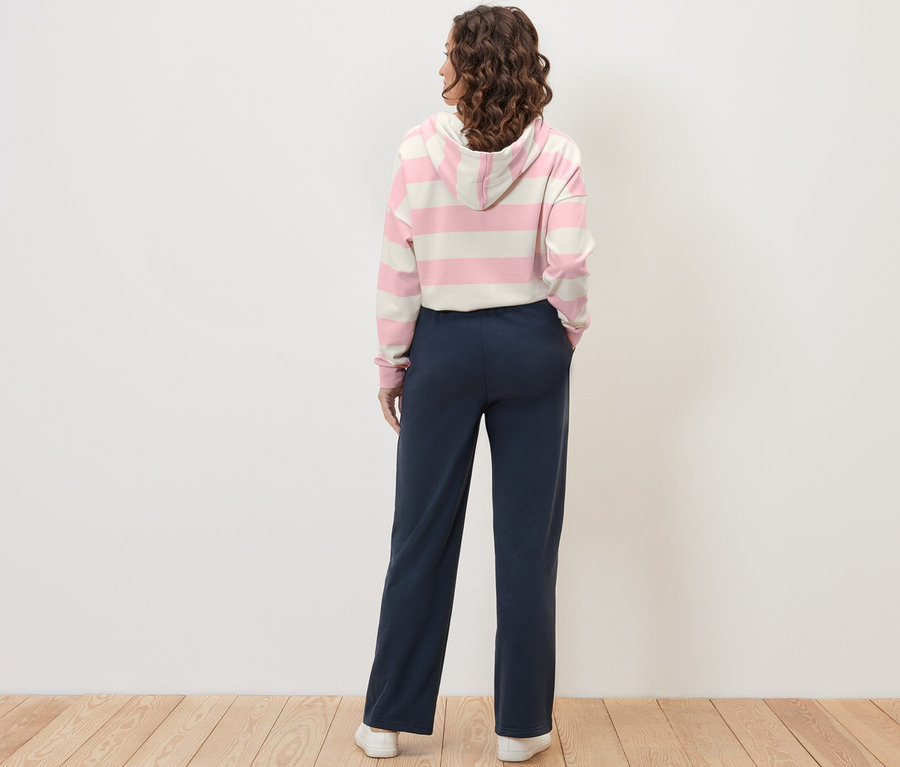 Femme vue de dos portant un pantalon de jogging bleu foncé.