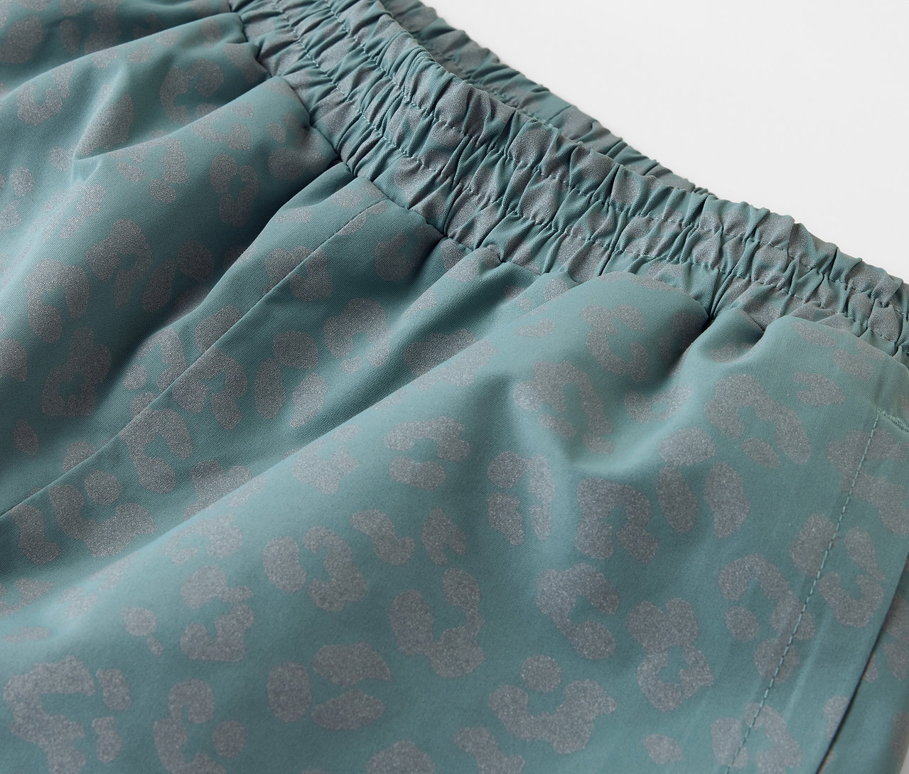 Gros plan sur un pantalon de pluie pour enfant avec des éléments réfléchissants.