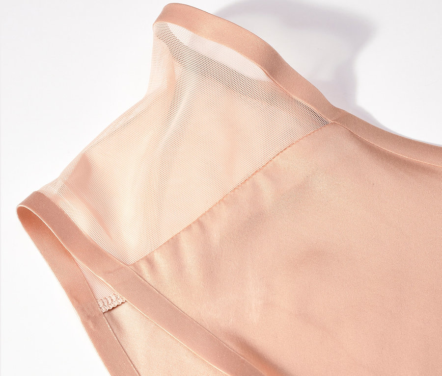 Gros plan sur un haut beige avec un empiècement transparent aux épaules.