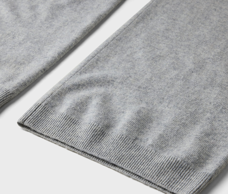 Gros plan sur un tissu tricoté gris avec une bordure côtelée.