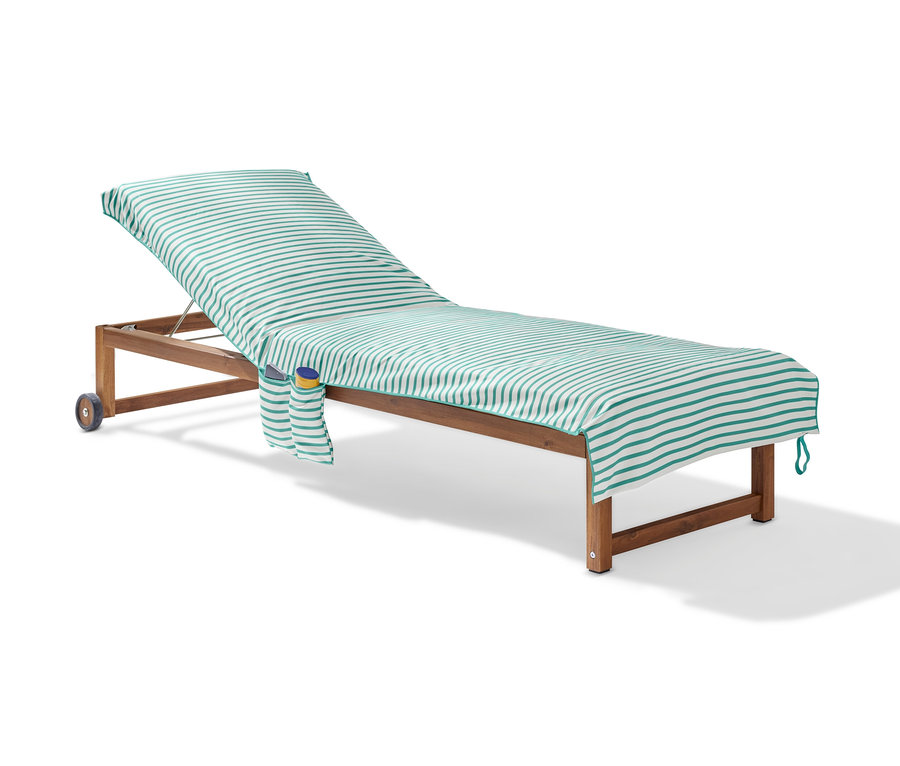 Serviette de bain d’extérieur rayée sur une chaise longue en bois.