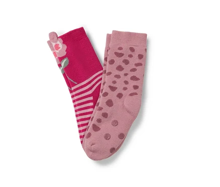 Deux paires de chaussettes : une paire rose avec un motif floral et des rayures, l’autre rose clair avec des pois marron.