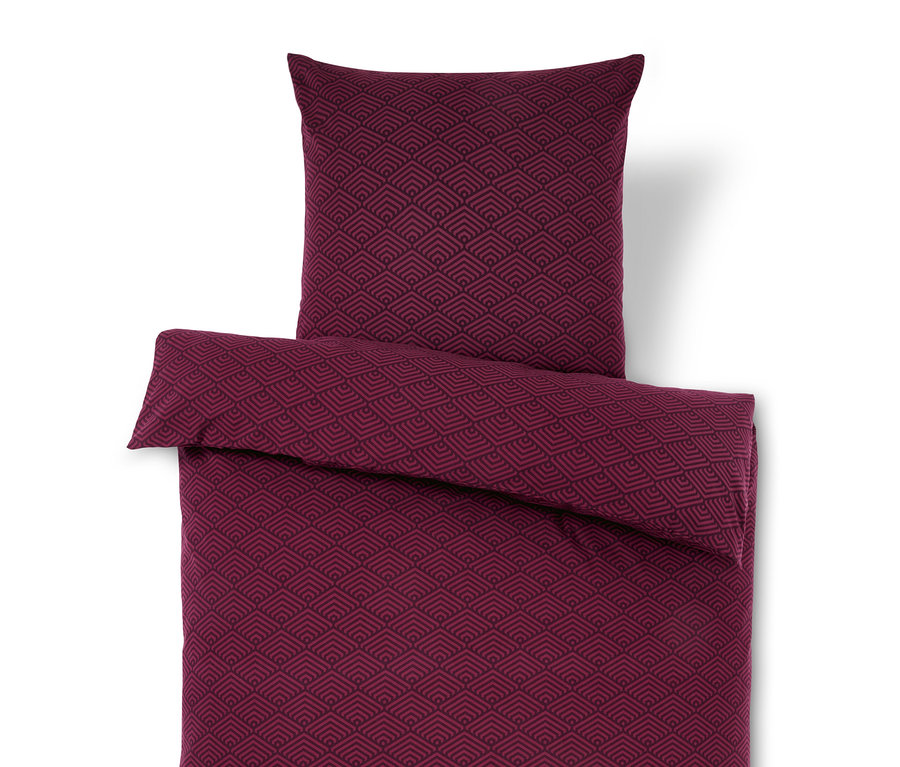 Parure de lit bordeaux avec motif géométrique et oreiller.