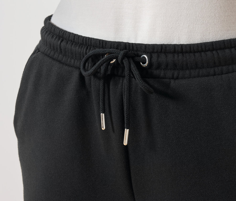Gros plan sur un pantalon de jogging noir avec cordon de serrage à la taille.