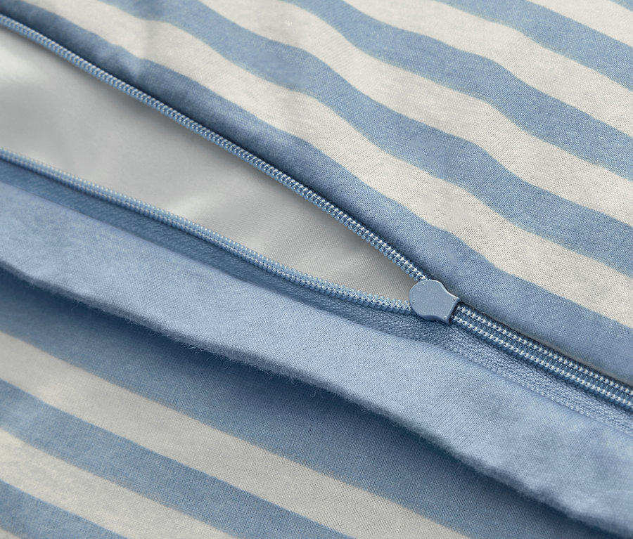 Gros plan sur une parure de lit en jersey d'hiver de taille standard avec des rayures bleues et blanches et une fermeture éclair.