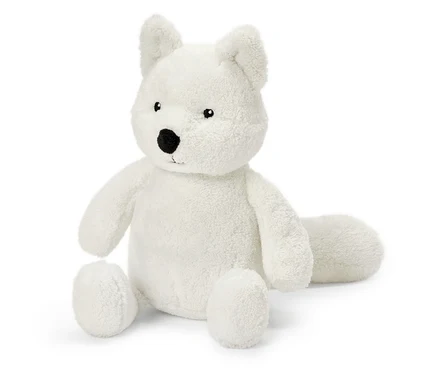 Une peluche de renard blanc est assise sur un fond blanc.