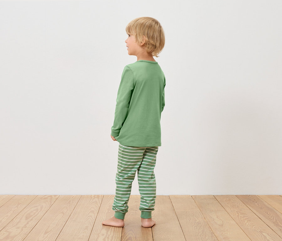 Garçon en pyjama vert regardant vers la gauche.