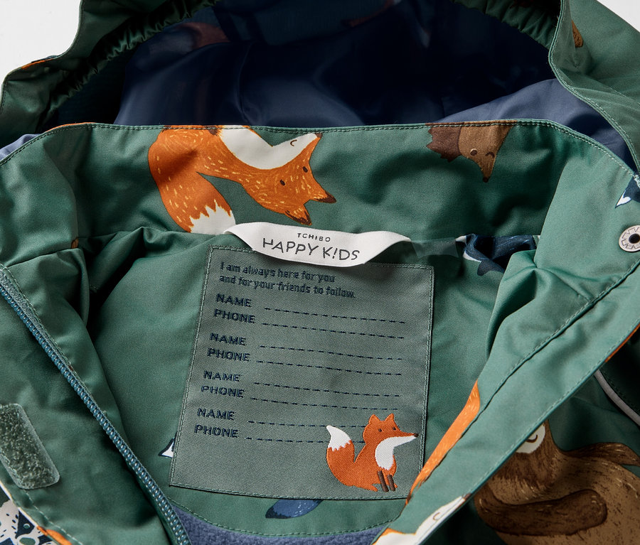 Détail d'une veste de pluie thermique pour enfant avec un motif d'animaux de la forêt.