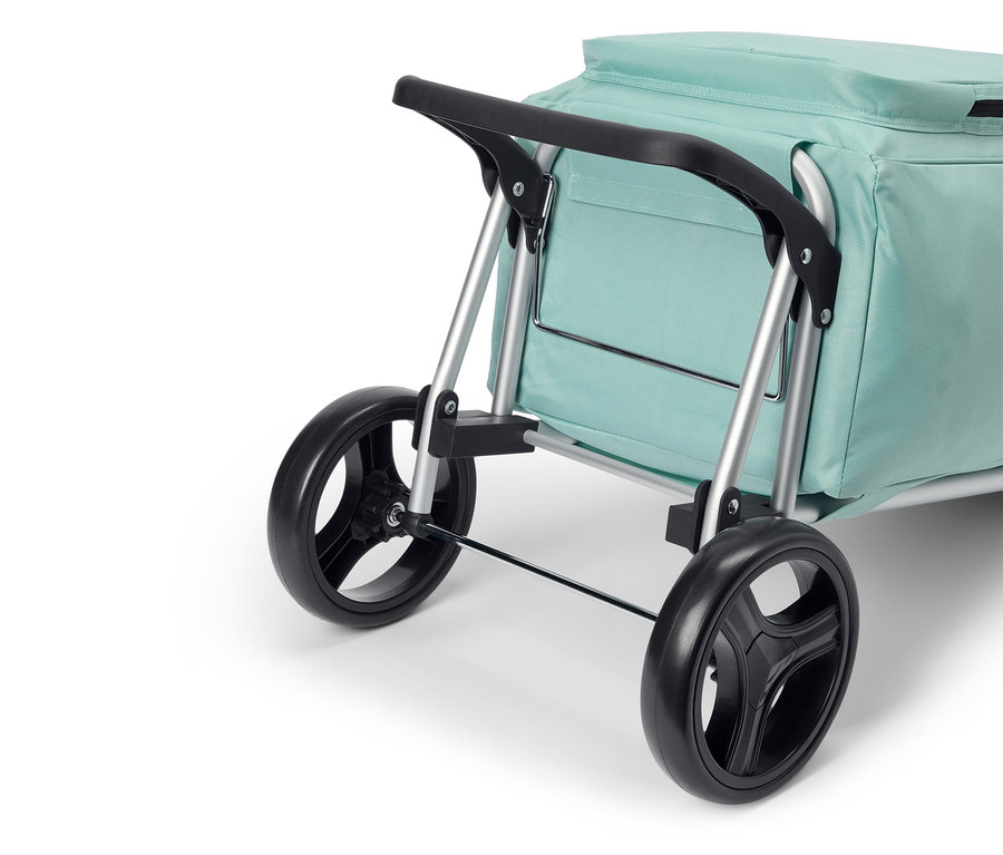 Gros plan d'un chariot de courses vert menthe avec des roues noires et un cadre argenté.