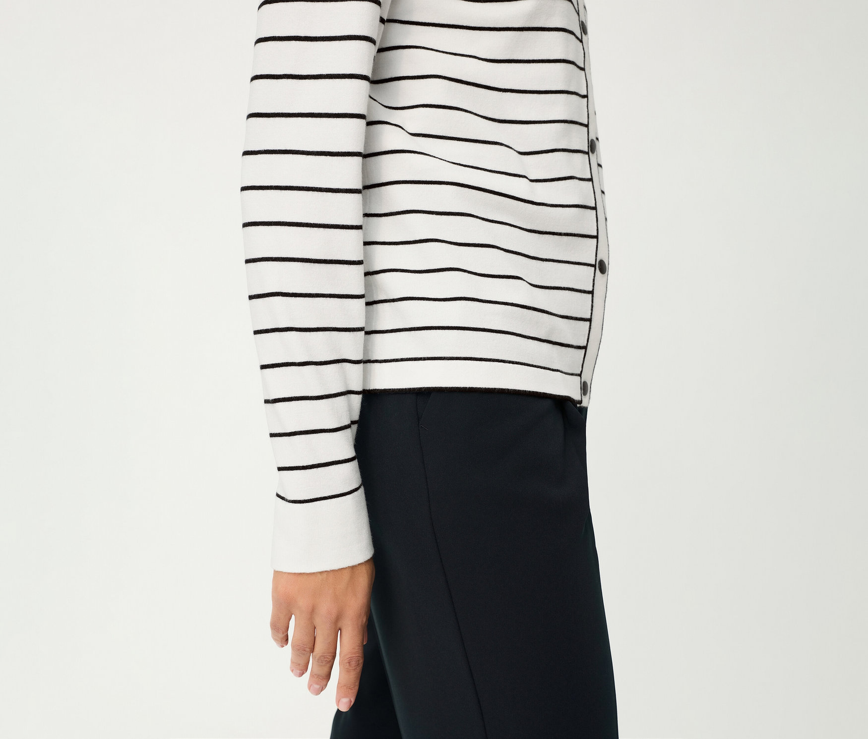 Une personne portant un cardigan rayé Olsen «
LA
» et un pantalon foncé sur fond blanc.