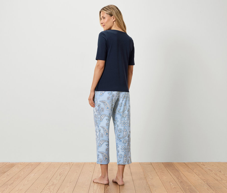 Femme vue de dos portant un t-shirt bleu marine et un pantalon bleu clair à motif cachemire.
