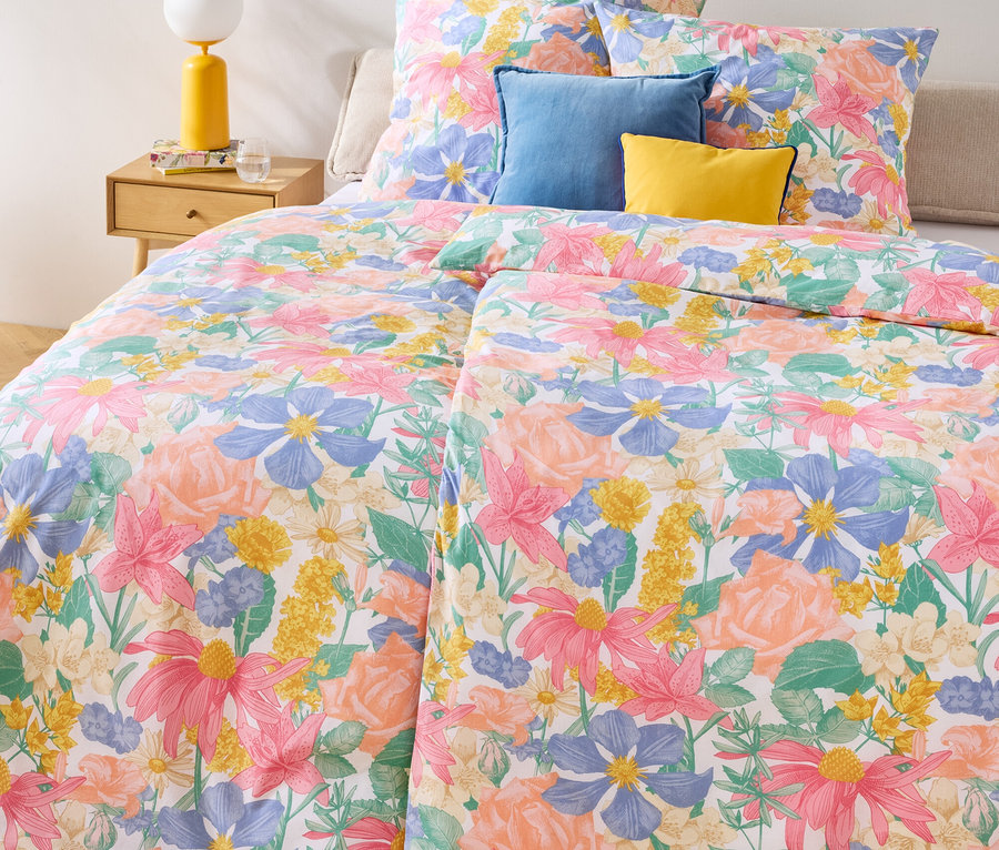 Linge de lit Renforcé à motif floral, tailles double, standard et king size sur un lit avec des coussins bleus et jaunes.