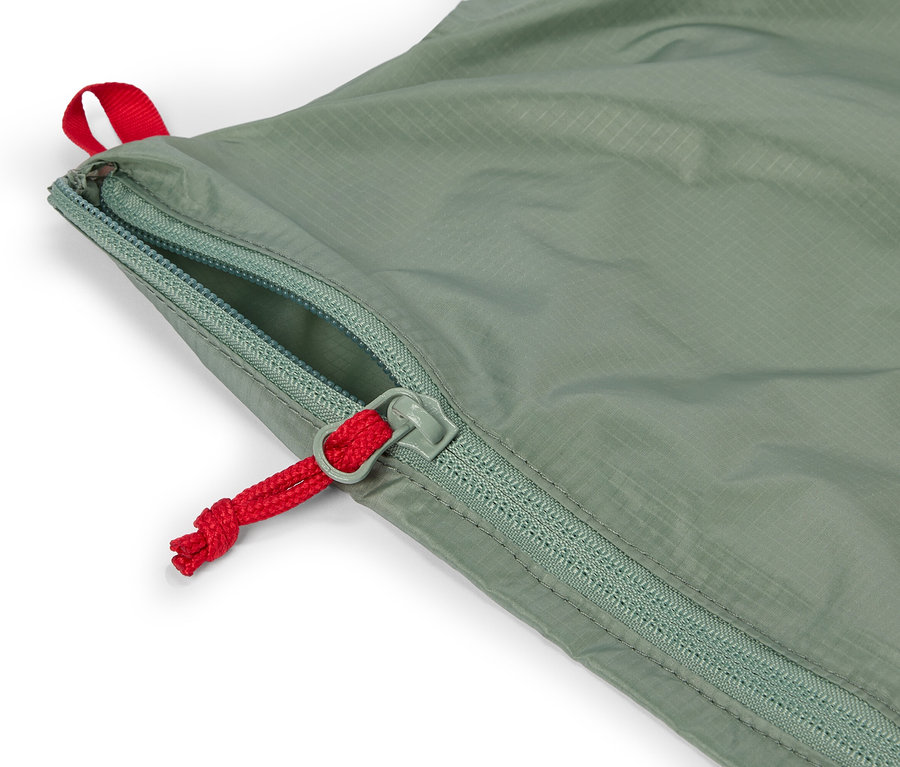 Gros plan sur un tissu vert olive avec une fermeture éclair partiellement ouverte avec un cordon rouge.