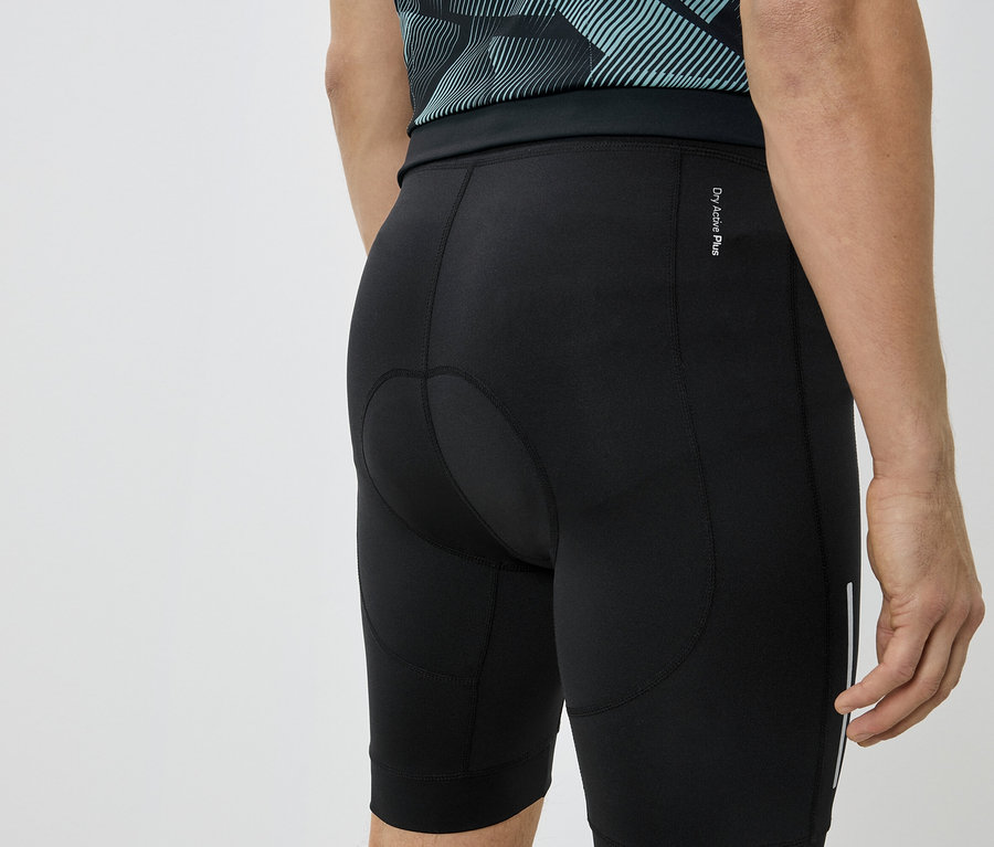 Gros plan du dos d'une personne portant un short de cyclisme noir et un t-shirt bleu-vert.