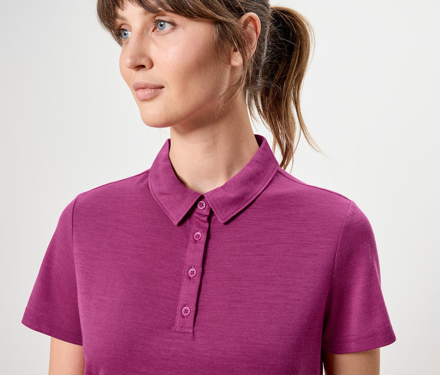Femme portant un polo rose à manches courtes.