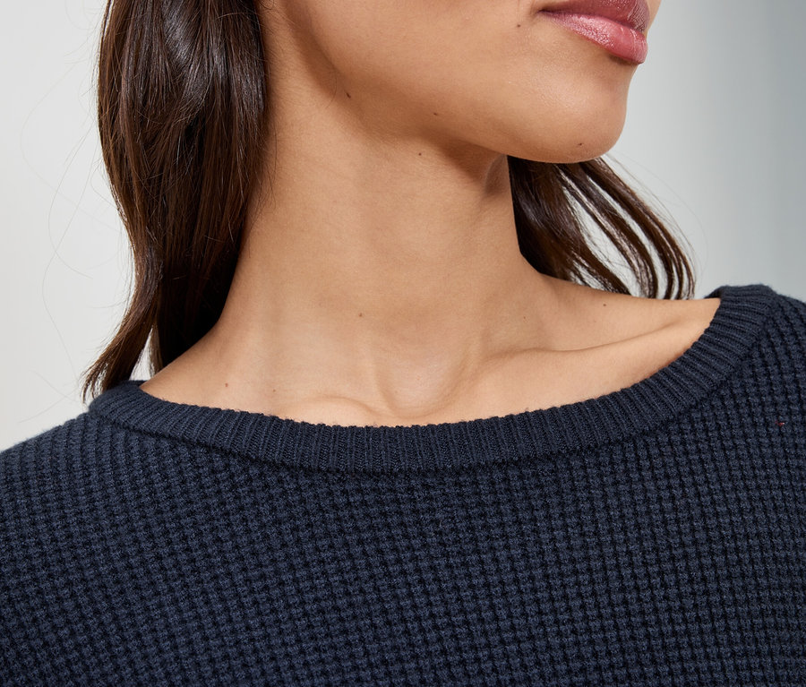 Gros plan d'une femme portant un pull bleu marine.