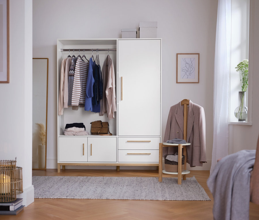 Dans la pièce, une armoire « Eklund » avec un côté gauche ouvert et un côté droit fermé.