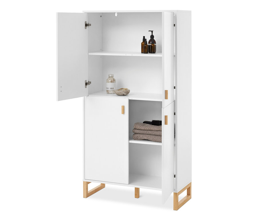 Armoire blanche avec pieds et poignées en bois, la porte supérieure gauche est ouverte, révélant deux étagères avec des bouteilles, un pot et des serviettes.