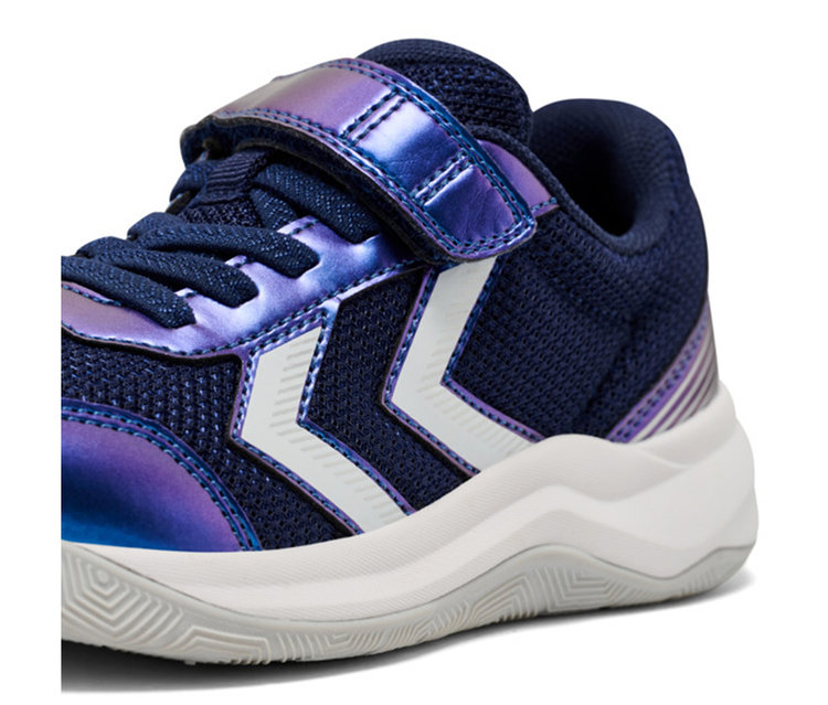 Baskets enfant bleu foncé avec détails irisés violets, rayures chevrons blanches, une bande velcro et une épaisse semelle blanche avec un dessous gris texturé.