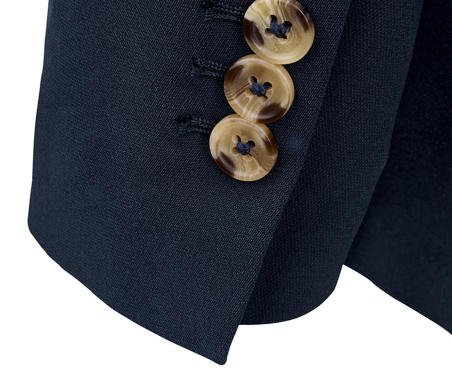 Détail d'un blazer en toile bleu marine avec des boutons marron.