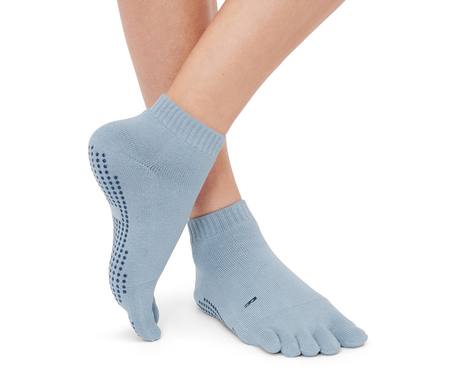 Pieds portant 1 paire de chaussettes à orteils bleu clair.