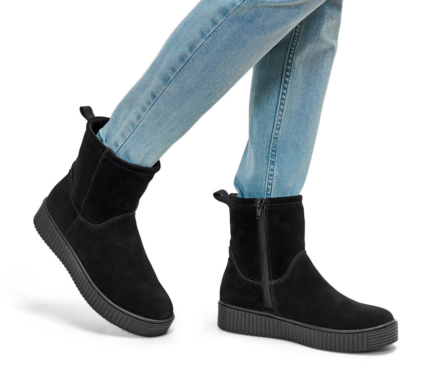 Jambes en jean et bottines en cuir velours.