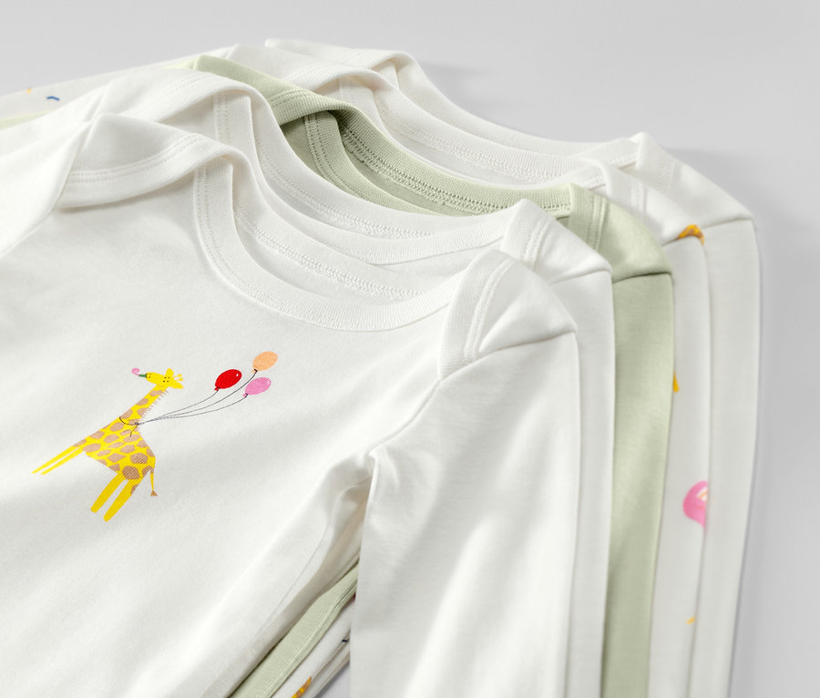Gros plan sur cinq bodys évolutifs pour bébé à manches longues, en blanc et vert clair, avec un imprimé girafe et ballons.