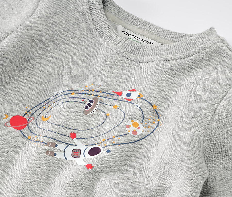 Détail d'un sweater pour enfant avec un motif spatial.