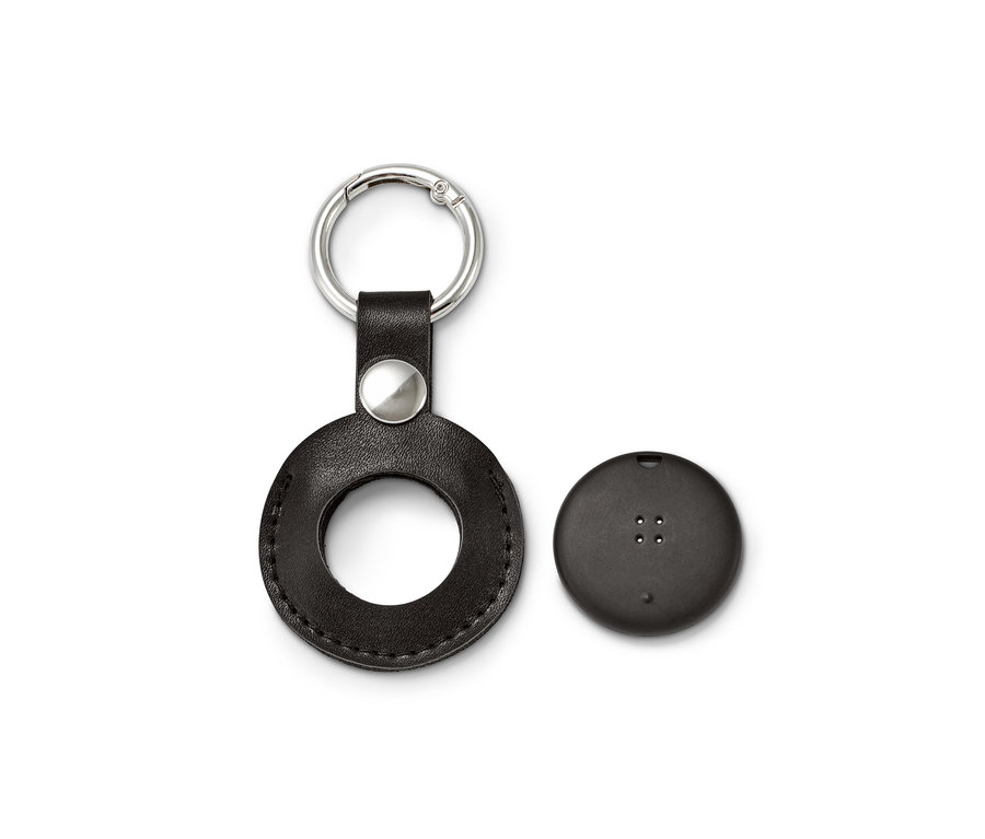 Porte-clés en cuir noir avec une découpe ronde à côté d'un tracker intelligent rond avec anneau porte-clé.