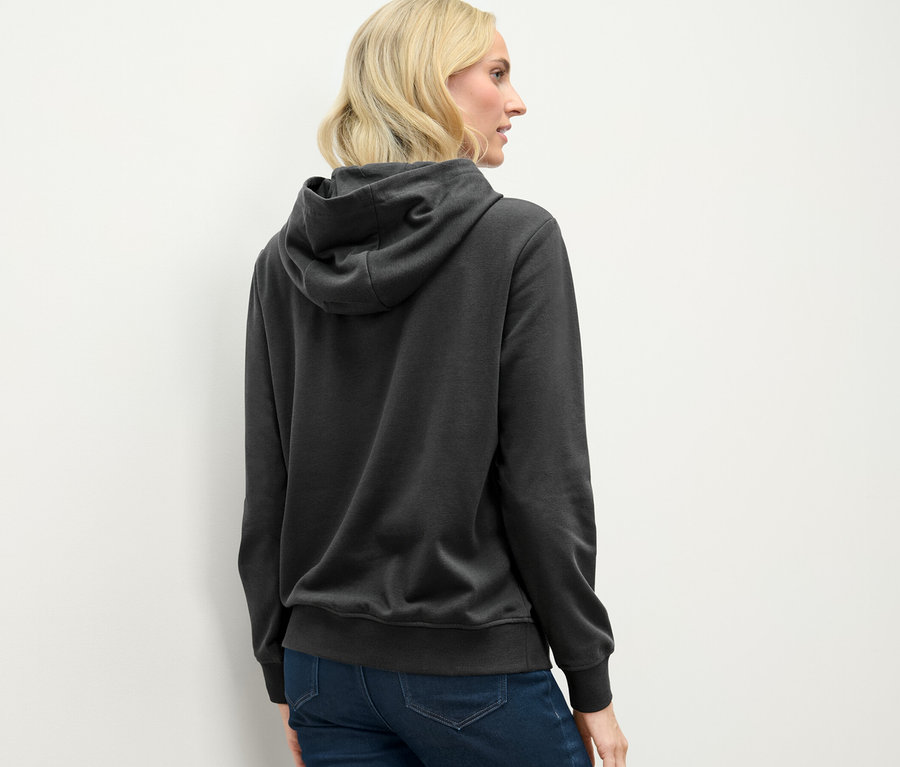 Vue arrière d'une femme blonde portant un sweat à capuche anthracite.