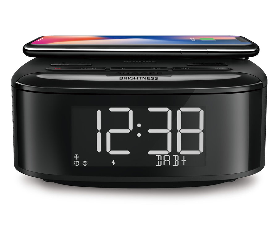 Radio-réveil DAB Philips « TAR7705 » noir avec téléphone portable sur le dessus.