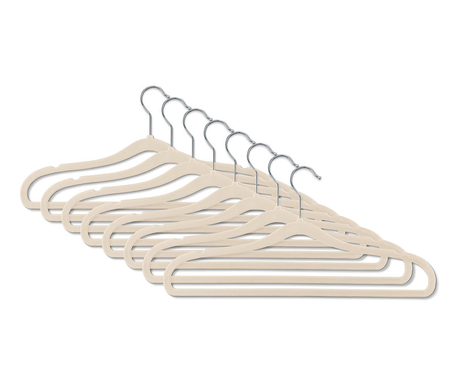 Huit cintres ultrafins beiges disposés en rangée.