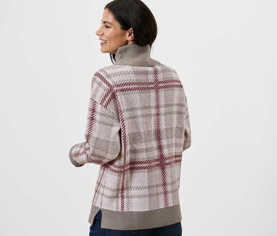 Femme portant un pull en maille à col roulé et un jean.