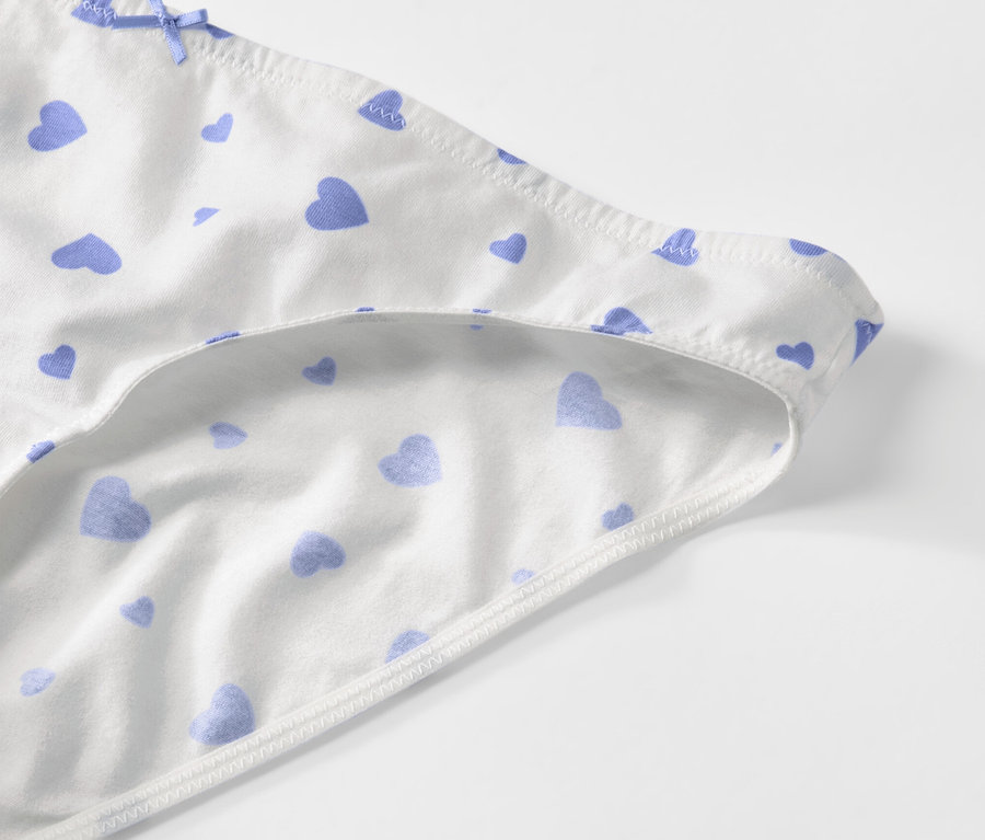Vue détaillée de 5 slips blancs à motifs de cœurs bleus.