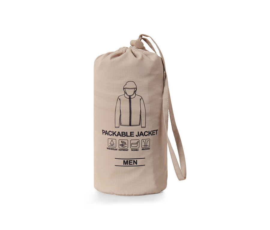 Une veste fonctionnelle « pack me » emballée dans un sac beige avec cordon de serrage.
