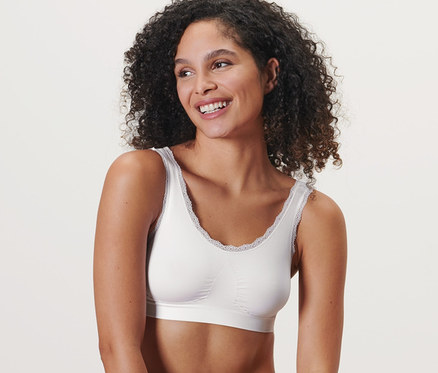Une femme est assise et porte une brassière sans coutures blanche.
