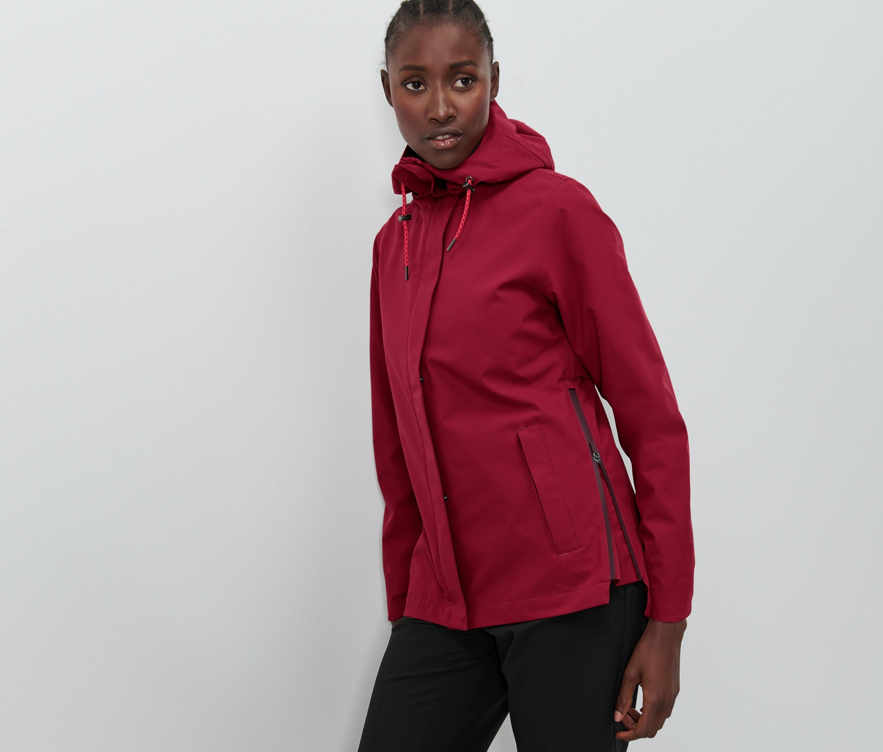 Femme posant dans une veste d'extérieur fonctionnelle bordeaux.