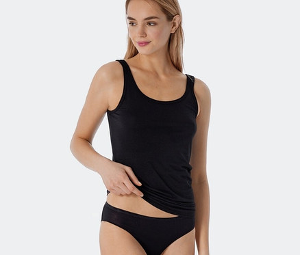 Une femme porte deux débardeurs à bretelles noirs à rayures avec modal de SCHIESSER.